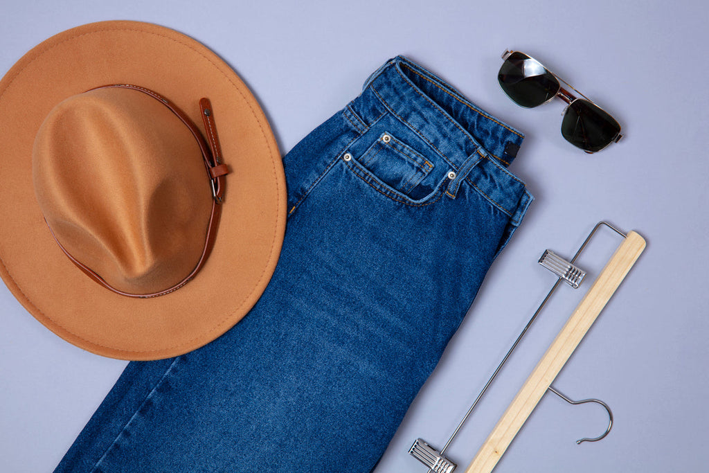 Denim jeans, hats, and glasses on table
