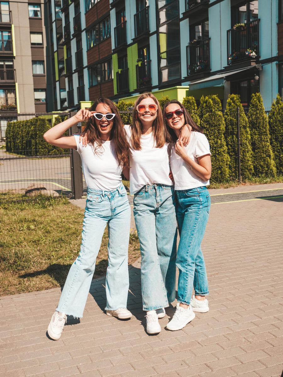 Three happy friends wearing denim jeans